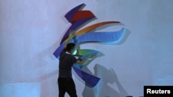 资料照片:一名男子在调整北京冬奥会的标识。(2021年9月17日)