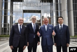 2018年5月8日,国际刑警组织主席孟宏伟(右)和秘书长斯托克,法国内政部长和英国威尔士亲王查尔斯王子在法国里昂的国际刑警组织总部门前合影。