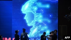 2024年9月10日在首尔举行的军事领域负责任人工智能(REAIM)峰会闭幕式前,参与者在电子图像前聊天。