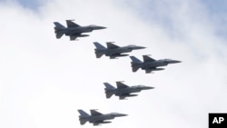 台湾空军F-16战机编队在一个庆祝双十节操演中飞越台北总统府上空。(2021年10月10日)