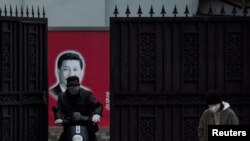 在上海,习近平画像前带口罩的人(2020年2月10日)
