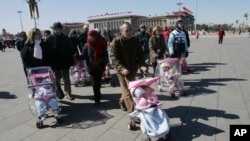 资料照片:2007年3月7日,一些西班牙夫妇带着他们新收养的中国孩子在北京天安门广场散步。