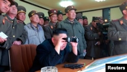 2013年3月14日,朝鮮中央通讯社发布的照片显示,朝鲜领导人金正恩和军事官员观看假设攻击韩国的军事演习