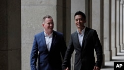 资料照:香港移民官梁镇罡和他的英籍同性婚姻伴侣史葛携手走在香港终审法院外。(2019年6月6日)