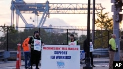 资料照片:码头工人在波士顿港附近一个集装箱码头入口前罢工。(2024年10月1日)