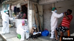 မွမ်ဘိုင်းမြို့မှာ ဒေသခံတွေကို COVID-19 စစ်ဆေးဖို့ Swab နမူနာယူနေတဲ့ ကျန်းမာရေးဝန်ထမ်းများ။ (စက်တင်ဘာ ၅၊ ၂၀၂၀)