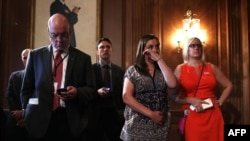 6月20日,桑迪胡克小学被杀害的校长道恩·霍斯普兰德女儿艾瑞卡·斯梅吉尔斯基(右二)在华盛顿国会聆听有关枪支管控的新闻发布会时抹下眼泪。