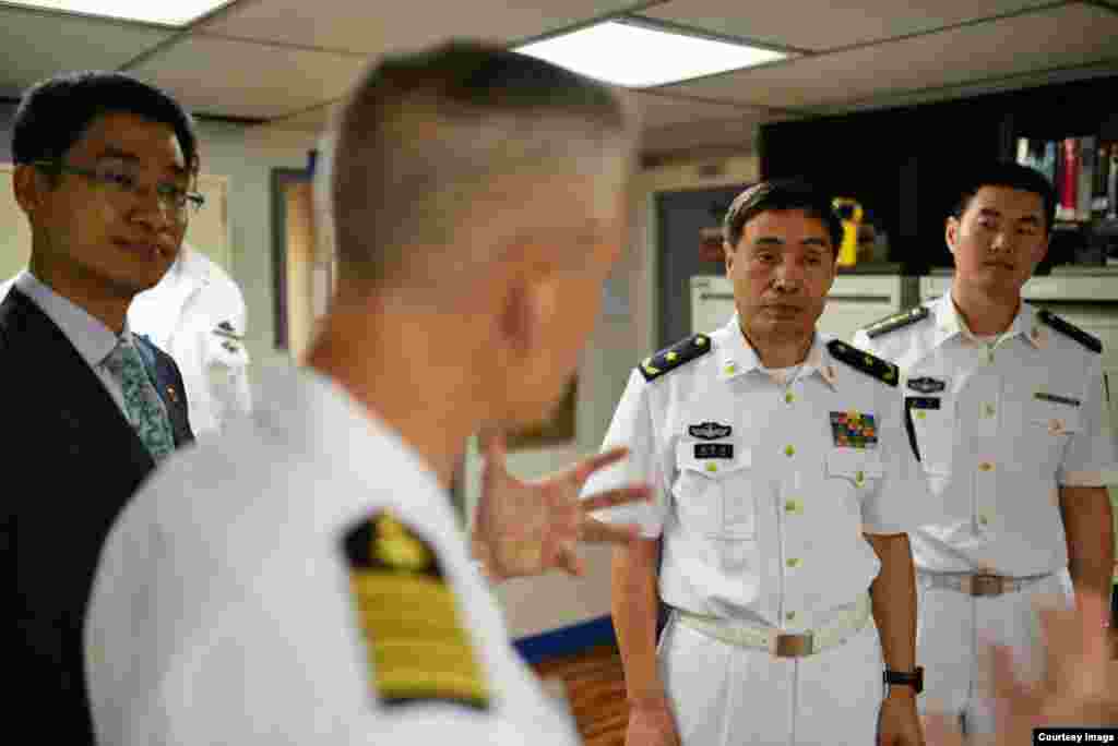 美国第七舰队旗舰“蓝岭号”在湛江进行港口访问,“蓝岭号”指挥官凯尔·希金斯上校与中国人民解放军海军中将沈金龙一起参观军舰 (2015年4月21日)。2017年1月,广州军区副司令员兼南海舰队司令沈金龙升任海军司令。