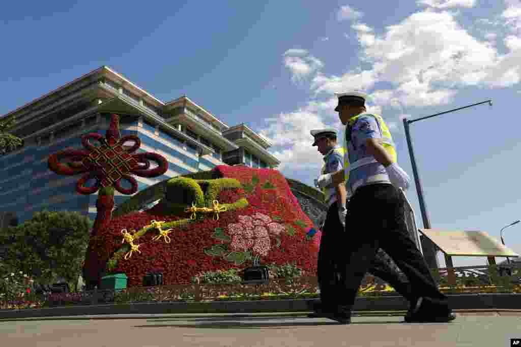 在北京 “一带一路”国际合作高峰论坛举行前夕,交通警察走过花坛。“一带一路”被中国称为是将改变世界大格局的顶级战略。美国派出由川普行政当局的高级顾问兼国家安全委员会负责东亚事务的马修·波廷格率领的代表团参加。