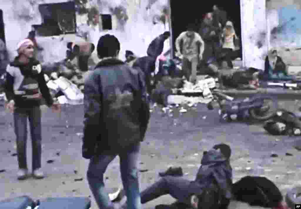 在政府军12月23日对叙利亚哈马郊外进行空袭后,叙利亚人帮助抬走在空袭中被炸死的人的遗体