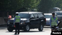 美中经贸磋商结束后,美国官员乘车离开美国驻华使馆(2018年5月4日路透社)