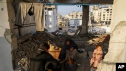 2025年3月9日,在加沙城以西,流离失所的巴勒斯坦人在联合国近东巴勒斯坦难民救济和工程处经营的一所学校在喝茶。