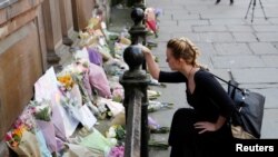 一名女士在美国流行歌手阿里安娜·格兰德的音乐会门口哀悼(2017年5月23日)