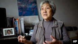 天安门母亲张先玲2014年4月29日在家中,身边是她19岁的儿子王楠的遗像。