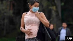 2020年3月16日哥伦比亚波哥大:戴口罩孕妇在等车