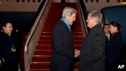 美国国务卿克里(左)2016年1月26日抵达北京访问,美国驻华大使鲍卡斯前往机场迎接。