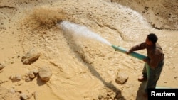 一名中国工人2011年1月16日在江西省南城县的一个稀土矿里工作。