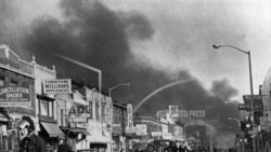 资料图片 - 在密歇根州底特律爆发种族骚乱后,底特律警方检查了距离密歇根州底特律市中心约3英里的第12街沿线的建筑物。许多商店和房屋被烧毁和抢劫。(1967年7月24日,)(美联社照片)