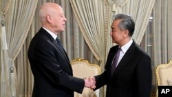 突尼斯总统赛义德与到访的中国外长王毅握手。(2024年1月15日)