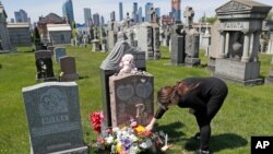 资料照片:2020年5月10日,莎朗·里维拉在“母亲节”这天在位于纽约各各他公墓的女儿坟前调整鲜花和其它纪念物品。她的女儿维多利亚2019年9月22日死于用药过量,年仅21岁。