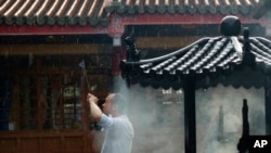 资料照片:一名男子在台北行天宫烧香。(2014年7月14日)