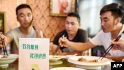 中国河北邯郸市一家餐馆桌子上立有“节约粮食杜绝浪费”的牌子。(2020年8月13日)法新社