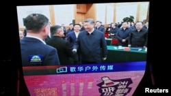 北京某购物中心的一块巨型屏幕播放新闻画面,显示中国领导人习近平在2月17日举行的一次民营企业座谈会上与阿里巴巴创始人马云握手的场景。(2025年2月17日)