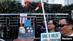 香港抗议者在圣诞节在中联办前摆放一张空椅子和刘晓波遗孀刘霞的照片,呼吁中国当局解除对刘霞的软禁。(2017年12月25日)