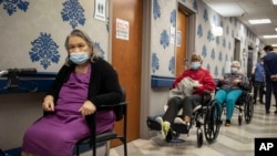 资料照片:纽约市哈莱姆区的哈莱姆护理与康复中心的居民排队等待接种新冠病毒加强针。(2021年1月15日)