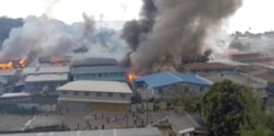 所罗门群岛的示威者在首都霍尼亚拉的中国城纵火后中国城里升起浓烟。(2021年11月25日)