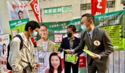 参与立法会新界西南地区直选的非建制派候选人刘卓裕(右一)与获得民主党批准以个人名义支持他的李洪波(中)12月8日共同派宣单呼吁市民支持。 (美国之音汤惠芸)