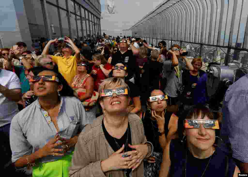 People watch the solar eclipse from the observation deck of The Empire State Building in New York City, Aug. 21, 2017.