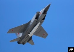 资料照:2018年5月9日,在俄罗斯莫斯科举行的庆祝二战结束和纳粹德国战败73周年的胜利日阅兵式上,一架俄罗斯空军米格-31K喷气式飞机携带一枚高精度的“匕首”高超音速导弹。