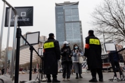 北京一个商场的入口处保安查看顾客的手机健康码。(2021年11月29日)