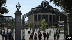 FILE - Students walk past Sather Gate on the University of California at Berkeley campus in Berkeley, Calif., May 10, 2018.