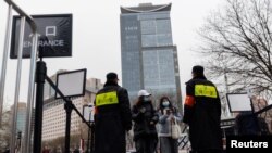 北京一个商场的入口处保安查看顾客的手机健康码。(2021年11月29日)