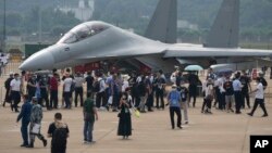 在珠海举行的中国国际航空航天博览会上,参观者在参观中国军方的电子战机歼-16D。(2021年9月29日)