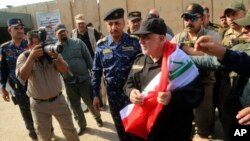 Thủ tướng Iraq Haider al-Abadi cầm quốc kỳ khi đến Mosul, Iraq, 9/7/2017.