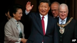 中国国家主席习近平(中)和英国首相卡梅伦2015年10月23日在曼彻斯特市政厅共进午餐后离开大楼。