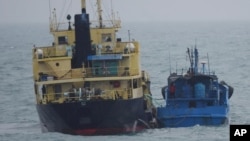 日本防务省称,2018年2月16日的这张图片中是悬挂朝鲜旗的运油船Yu Jong 2号(左)和闽宁德油078号。外界担心,这两艘船只传递的货物可能违反了联合国对朝鲜的制裁令。