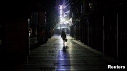 2020年2月1日,江西九江一女子走过一条寂静的商业街。由新型冠状病毒导致的武汉肺炎疫情仍在中国肆虐。(路透社)