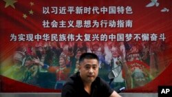 一个行人路过北京街头宣传习近平中国梦的宣传广告牌。(2020年9月11日)