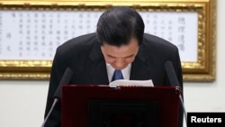 Taiwan President Ma Ying-jeou bows after announcing his resignation from the Kuomintang (KMT) party chairman position during the party's central standing committee in Taipei, December 3, 2014.
