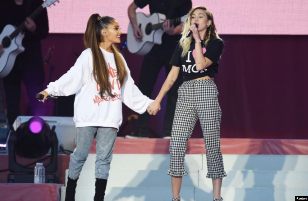 美国流行歌手爱莉安娜·格兰德(Ariana Grande)和歌手、演员麦莉·希拉(Miley Cyrus)在曼彻斯特慈善音乐会上演唱(2017年6月4日)。麦莉·希拉曾经主演过美国迪斯尼公司出品的青少年电视情景喜剧《孟汉娜》