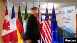 2025年3月12日,在加拿大魁北克省拉马尔贝举行的七国集团外交部长会议之前,一名男子在黎塞留庄园走过七国集团成员国的国旗。