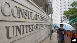 资料照片:中国2003年爆发非典疫情后,香港一位男子4月2日戴口罩行走在美国驻香港总领馆外面的人行道上。