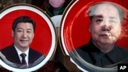 北京天安门广场附近一个纪念品商店出售的中国国家主席习近平(左)与前中共领导人毛泽东头像的磁盘。(2016年1月17日)