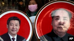 北京天安门广场附近一个纪念品商店出售的中国国家主席习近平(左)与前中共领导人毛泽东头像的磁盘。(2016年1月17日)