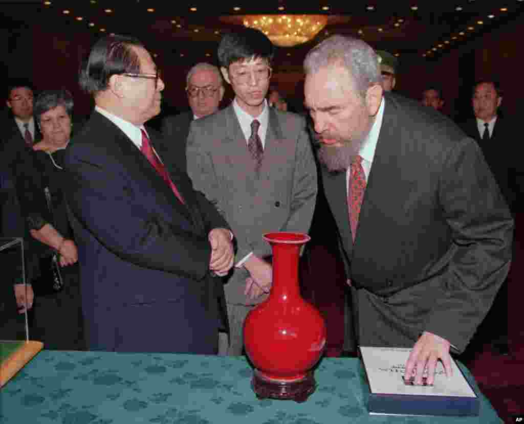1995年11月30日,江泽民向古巴领导人卡斯特罗展示工艺品瓷瓶