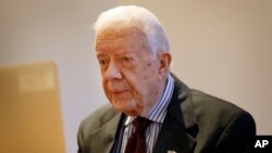 Cự Tổng thống Mỹ Jimmy Carter lắng nghe trong một cuộc phỏng vấn qua video trên máy tính laptop với hãng tin AP ở London, ngày 2 tháng 2, 2016.